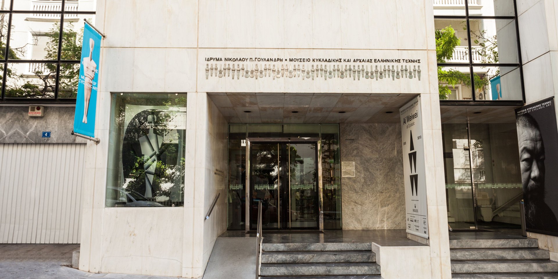 Entrance of the Museum of Cycladic Art with banners and posters of current exhibitions.